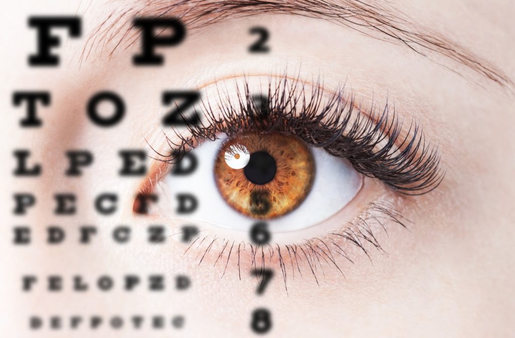 A close-up image of a hazel-colored eye, with an overlay image of letters from a Snellen eye chart.