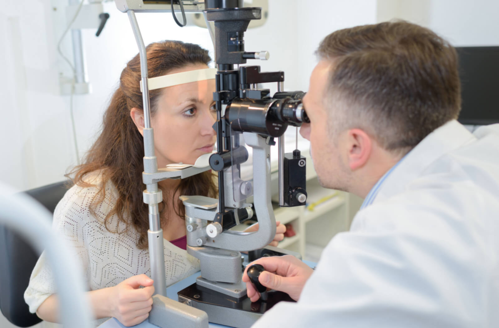 An optometrist conducting an eye exam on his patient to prescribe the right contact lens.