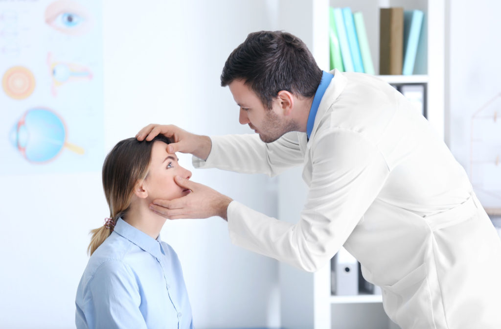An eye doctor checking the eyes of his patient for signs of retinal tear.