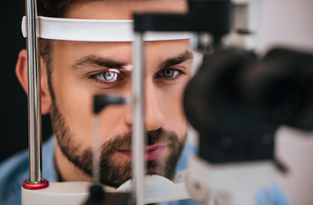 A close-up of a man undergoing an eye exam to check for signs of retinal detachment.