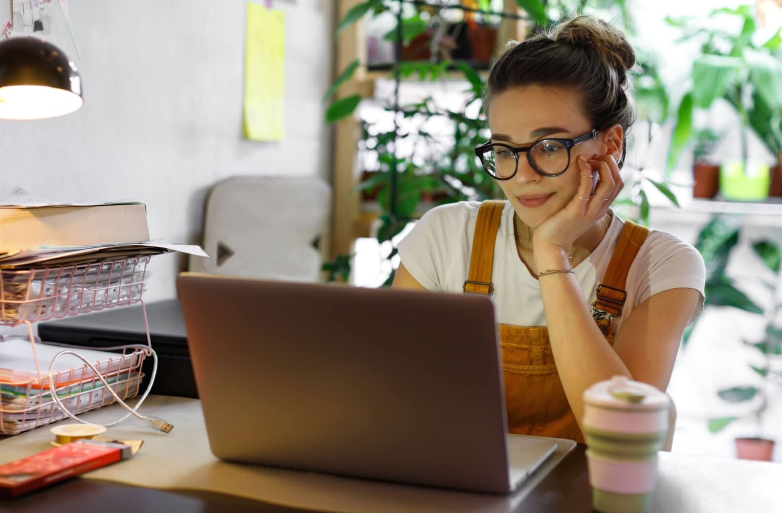 A person wearing prescription blue light glasses while working at their computer to help filter out blue light.