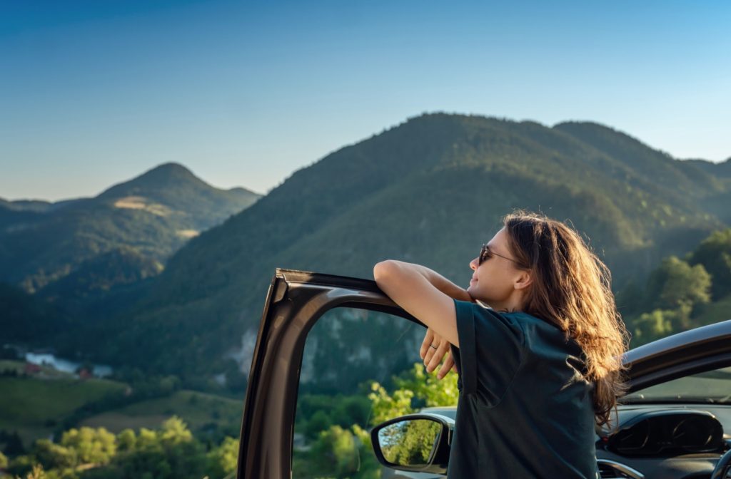 A person looking outside at a landscape with protective eyewear due to sunlight sensitivity.