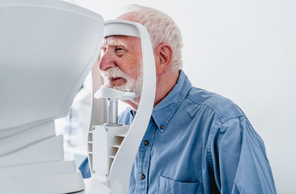 A patient at an eye exam with their chin resting on a pre-testing machine, having their eyes assessed for cataract management
