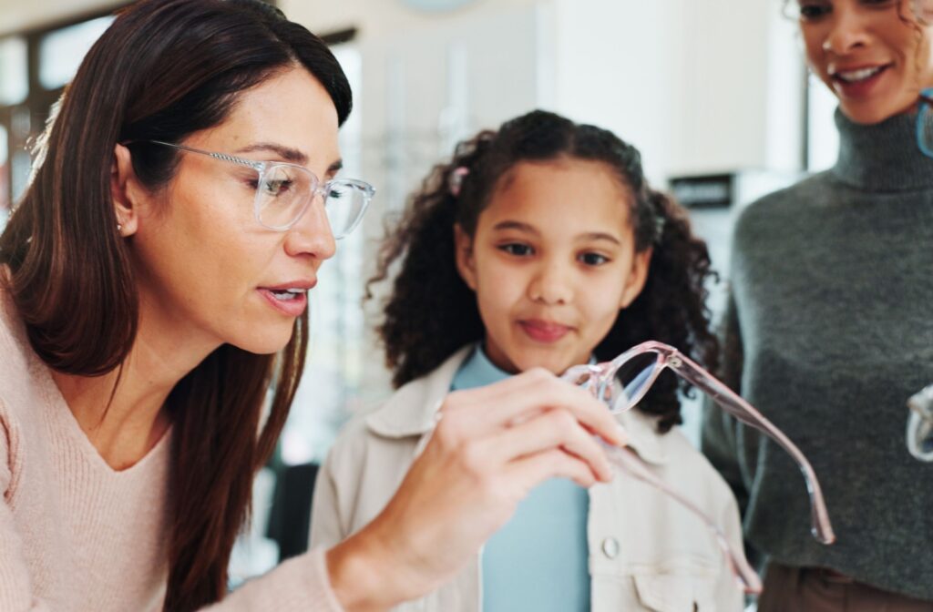 A child and their parent picking out new glasses at their optometrist's office.