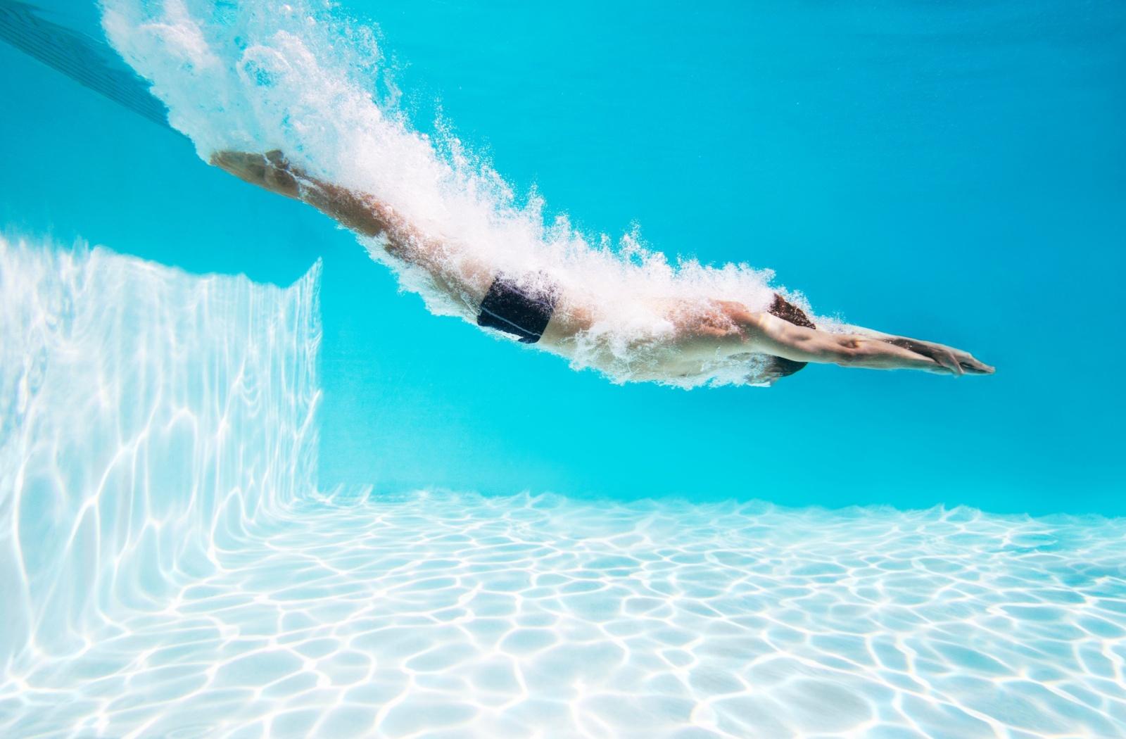 A person diving into a swimming pool.